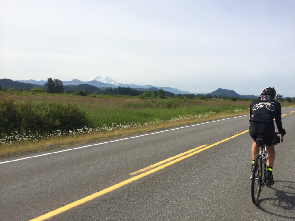 Drewski rides by with Mt. St. Helens in the distance. Photo: D. Banks